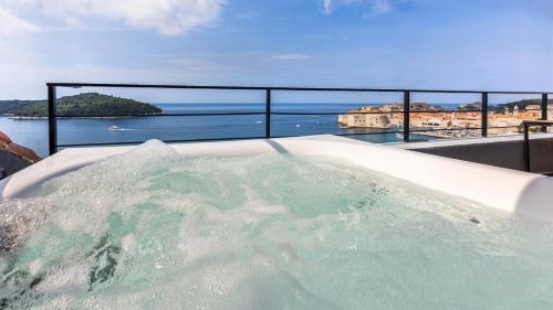 a bath tub filled with water next to the ocean at Dubrovnik Old Town Apartments in Dubrovnik