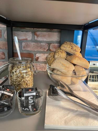 un comptoir avec des bols de pain et un pot de noix dans l'établissement Kragerø Hotell, à Kragerø