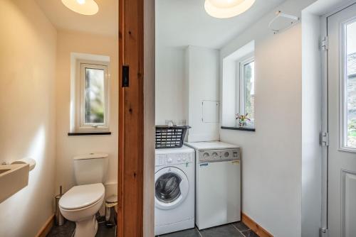 ein Badezimmer mit einer Waschmaschine und einem WC in der Unterkunft Ty Capel Jeriwsalem in Trawsfynydd
