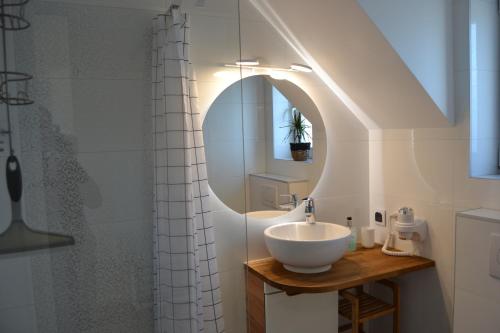 a bathroom with a sink and a mirror at Apartment Aurora in Dziwnówek