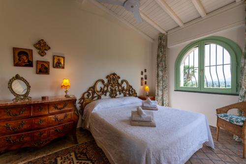 een slaapkamer met een bed, een dressoir en een raam bij Villa with pool & jacuzzi in Taormina