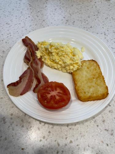 a white plate with breakfast food on a table at Amberlea B&B in Hokitika