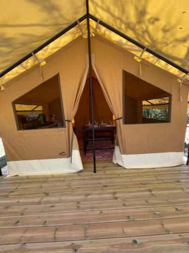 een tent met een houten vloer en een tafel binnen bij Camping Beaussement Samouraï in Chauzon