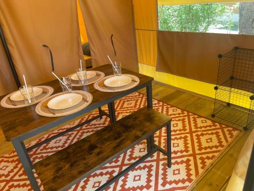 een kamer met een tafel met borden erop bij Camping Beaussement Samouraï in Chauzon