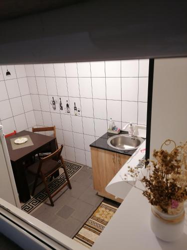 a small kitchen with a sink and a table at Apartman Centar 2 in Kruševac