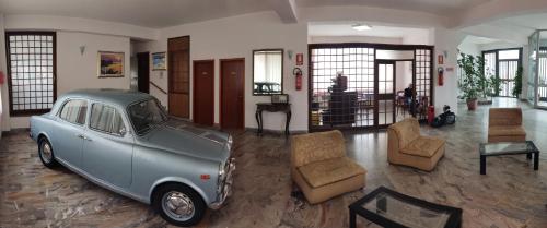 an old blue car parked in a living room at Hotel Il Dollaro in Villa San Giovanni