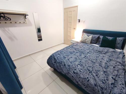 a bedroom with a bed with a blue comforter at The Nyor Guesthouse Tok Jembal Kuala Terengganu in Kuala Terengganu