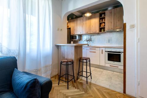 een keuken met een aanrecht en 2 barkrukken bij Zoe Apartment in Split