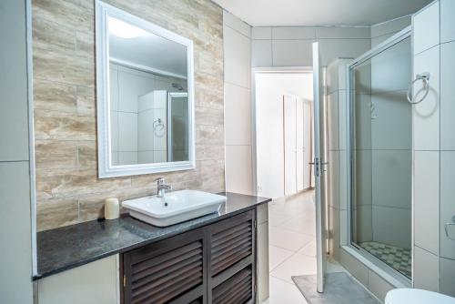 y baño con lavabo y ducha. en 304A Santorini -Margate RSA, en Margate