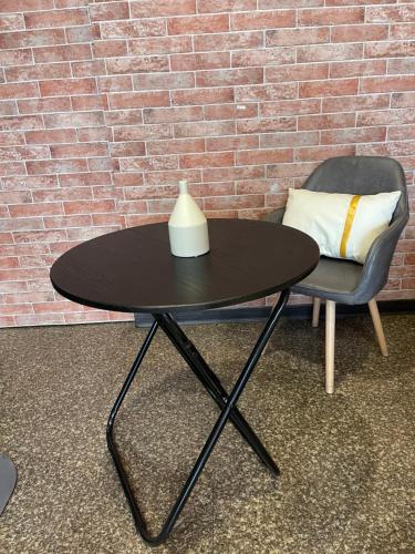 a black table and a chair and a pillow at American Style Rende in Tainan