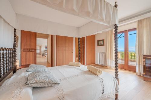 ein Schlafzimmer mit einem großen Bett mit Baldachin in der Unterkunft Ca Nostra de Esporles Charming Estate at Esporlas for families in Esporlas