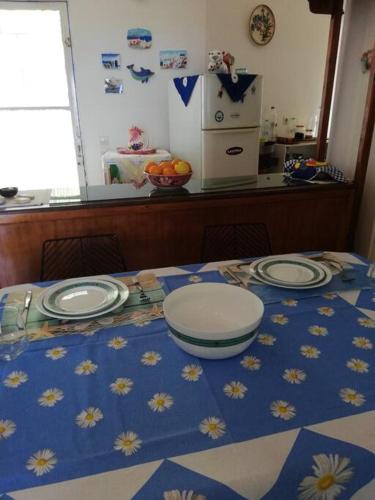 a table with plates on a blue and white table cloth at Μαγευτική θέα στη θάλασσα in Loukísia