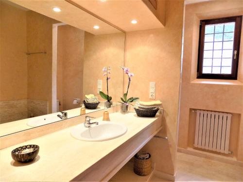 La salle de bains est pourvue d'un lavabo et d'un grand miroir. dans l'établissement Ca Nostra de Esporles Charming Estate at Esporlas for families, à Esporlas