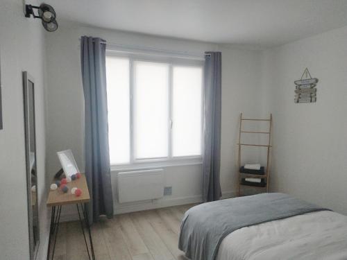 1 dormitorio con cama y ventana grande en Charmant logement à 2 pas de la plage en Le Portel