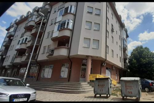 a large building with a car parked in front of it at Cozy studio apartment at center of Bijeljina in Bijeljina