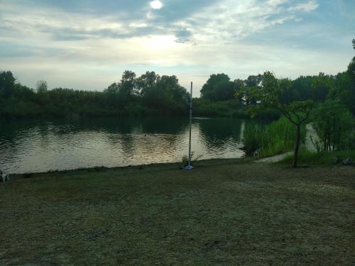 una vista de una masa de agua con un poste en ella en CAMPING DOMAINE DES ISCLES mobil-home climatise en La Roque-dʼAnthéron