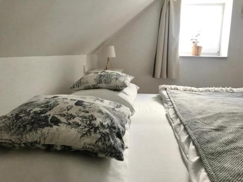 a bedroom with two pillows on a bed with a window at Penzion Kvilda - Luční in Kvilda