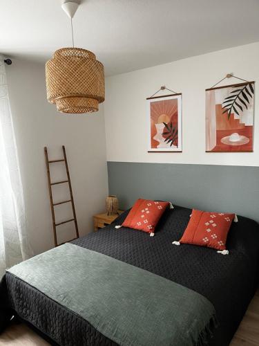 - une chambre avec un lit doté d'oreillers rouges et verts dans l'établissement La Bergerie, au Cap d'Agde