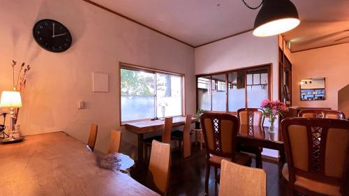 a dining room with a table and a clock on the wall at Sanga Nikko in Nikko