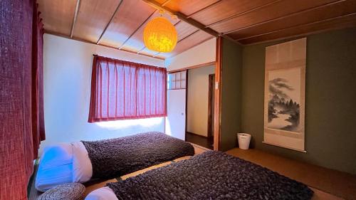 1 dormitorio con 2 camas y ventana en Sanga Nikko, en Nikko