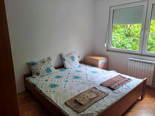 een kleine slaapkamer met een bed en een raam bij Dramski apartment in Skopje