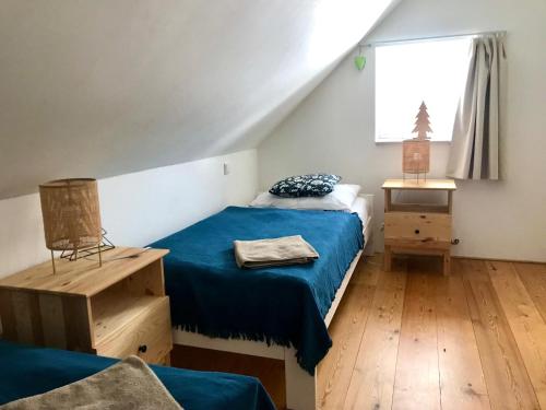 a bedroom with a blue bed and a window at Penzion Kvilda - Luční in Kvilda