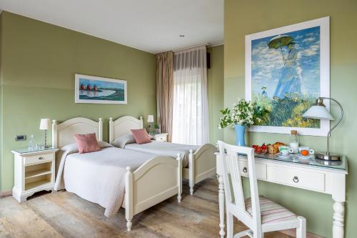 ヴィッラフランカ・ディ・ヴェローナにあるHotel San Pietroのベッドルーム1室(ベッド1台付)が備わります。壁には絵画が飾られています。