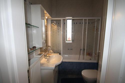 a bathroom with a sink and a shower and a toilet at Fourdeck Villa in Posidhonía