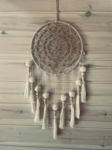 a dream catcher with tassels on a wall at BALTICO Domki Letniskowe in Sarbinowo