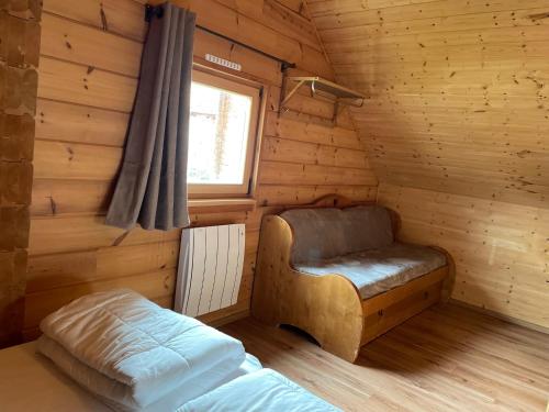a room with a bed and a window in a log cabin at Chalet Résivacances n°32 - La Joue du Loup in Le Dévoluy