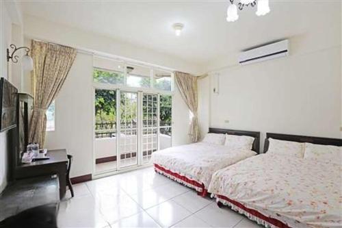 Jiji的住宿－風櫃梅休閒民宿一館，白色的卧室设有床和窗户