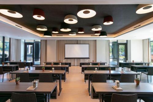 a dining room with tables and a projection screen at Hotel Citrine, Palo Alto, a Tribute Portfolio Hotel in Palo Alto