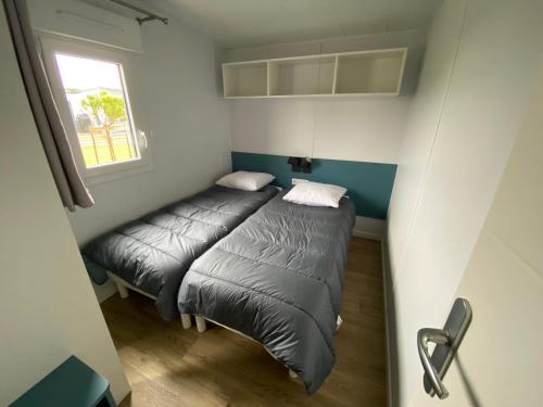 une petite pièce avec un lit et une fenêtre dans l'établissement Cottage moderne en bord de mer, à Bretignolles-sur-Mer