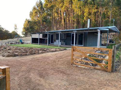 a house with a fence in front of it at Preston Valley Country Cabin in Lowden