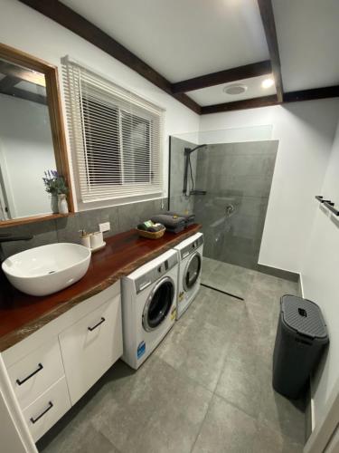 a bathroom with a sink and a washing machine at Preston Valley Country Cabin in Lowden
