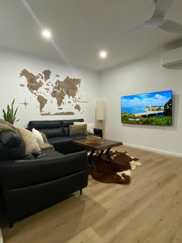 a living room with a black couch and a table at Preston Valley Country Cabin in Lowden