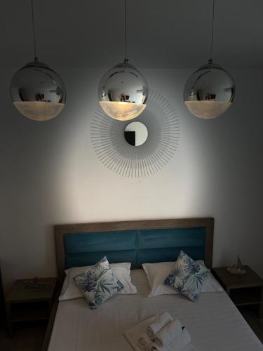 a bedroom with a bed with two lights and a mirror at Pensiunea CASID in Eforie Nord