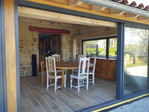 une véranda avec une table et des chaises dans l'établissement Gîte du Cèdre, à Courpière