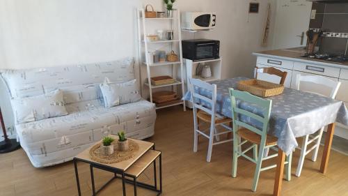 un salon avec une table et un canapé dans l'établissement Les Becs - Appartement bord de mer, 1 chambre, à Saint-Hilaire-de-Riez