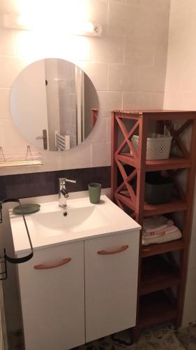 une salle de bain avec un lavabo et un miroir dans l'établissement Les Becs - Appartement bord de mer, 1 chambre, à Saint-Hilaire-de-Riez