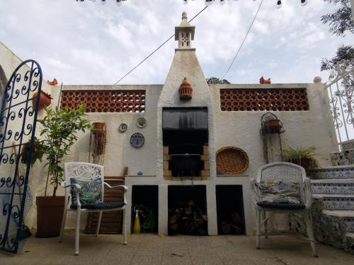 a building with a tower with chairs in front of it at Casa Aleg in Albufeira