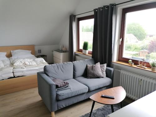 a living room with a couch and a bed at Ferienwohnung Abby in Butjadingen