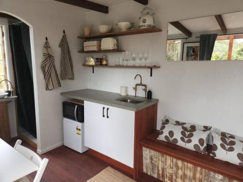 uma cozinha com um lavatório e uma bancada em Bellingen Hideaway Tiny Home- Breathe. Discover. Renew. em Bellingen