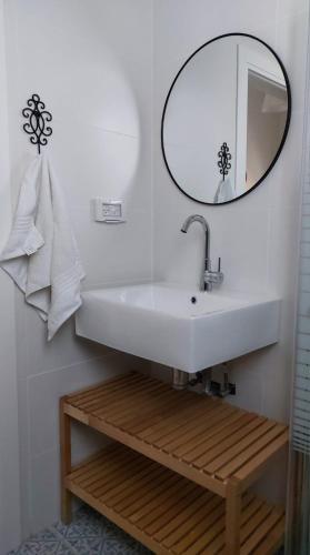 a bathroom with a white sink and a mirror at נצר- צימר אירוח כפרי in Kerem Shalom