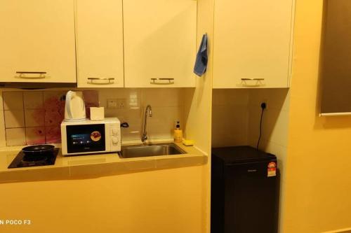 a small kitchen with a sink and a microwave at CQ1101- SELF CHECK-IN- WI-FI - NETFLIX-PARKING-BALCONY- CYBERJAYa, 2063 in Cyberjaya