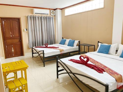 a room with three beds with red towels on them at Ali Local Home in Vientiane