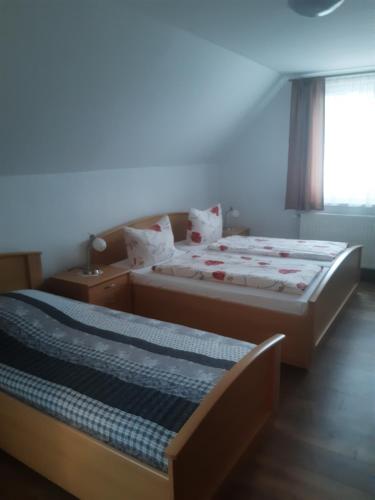 two beds in a small room with a window at Bed and Breakfast 2 in Korswandt