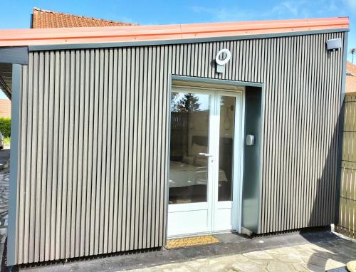 un edificio de metal ondulado con una puerta blanca en Gîte •Côte d'Opale •2 personnes en Halinghen