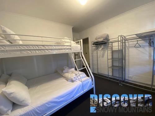 een slaapkamer met 2 stapelbedden met witte kussens bij Alpine Mountain View 3 in Jindabyne