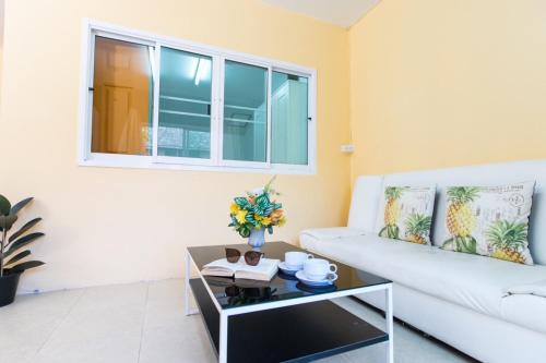 a living room with a white couch and a coffee table at MANDARIN LODGE by victor in Hua Hin